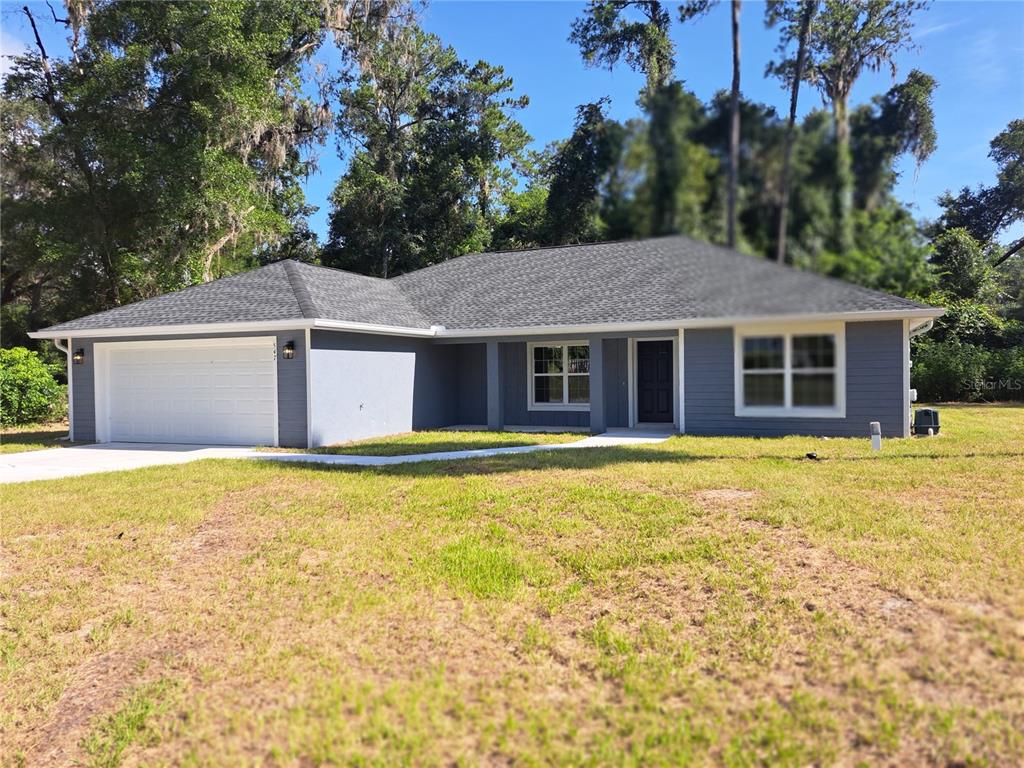 A single-story house with gray siding, a dark shingled roof, and an attached two-car garage — 547 GRAPEWOOD LN., CITRUS SPRINGS, FL