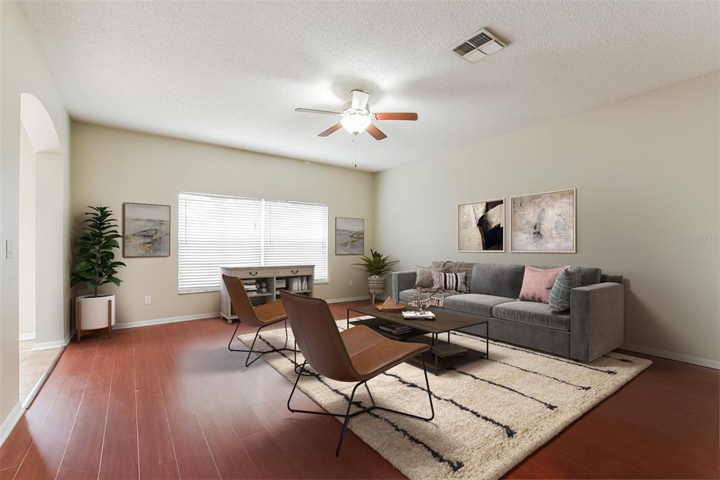 A living room features a gray sofa, two leather chairs, and a rug on wood flooring — 2043 HAMMOCK MOSS DRIVE, ORLANDO, FL