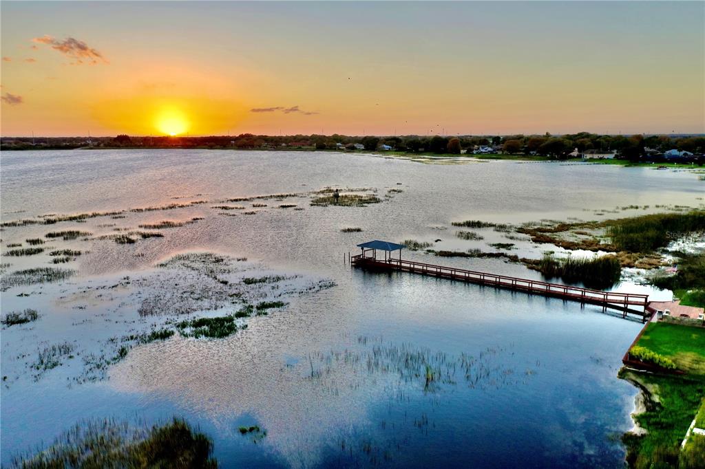An aerial view of a wooden pier extending into a lake at sunset — 77 W LAKE DAMON DRIVE, AVON PARK, FL