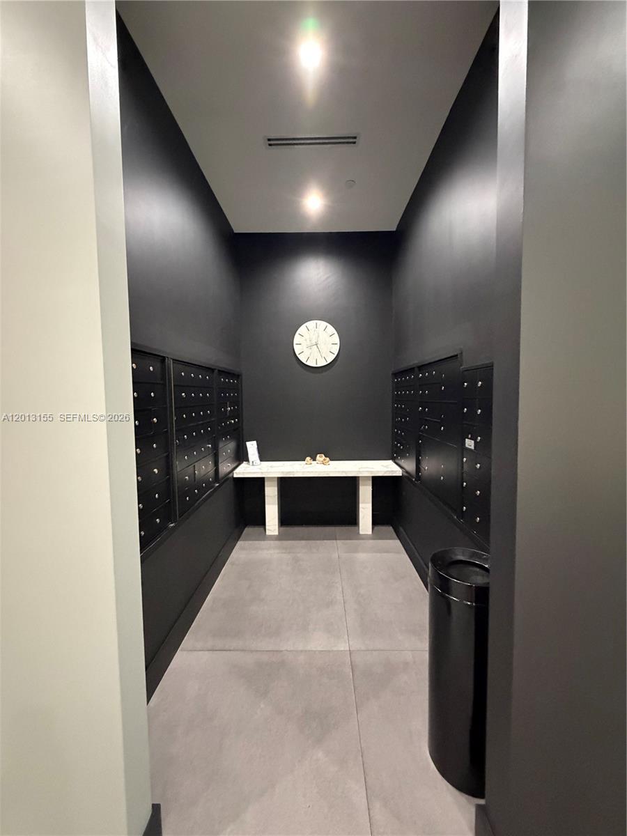A kitchen island with dark countertops and wood cabinets overlooks a living area with balcony access — 4100 Salzedo St # 508, Coral Gables FL 33146, CORAL GABLES, FL