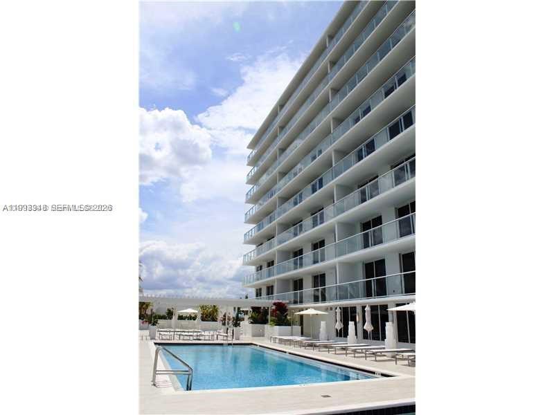 A multi-story apartment building stands next to an outdoor swimming pool with lounge chairs — 4250 Biscayne Blvd # 815, Miami FL 33137, MIAMI, FL