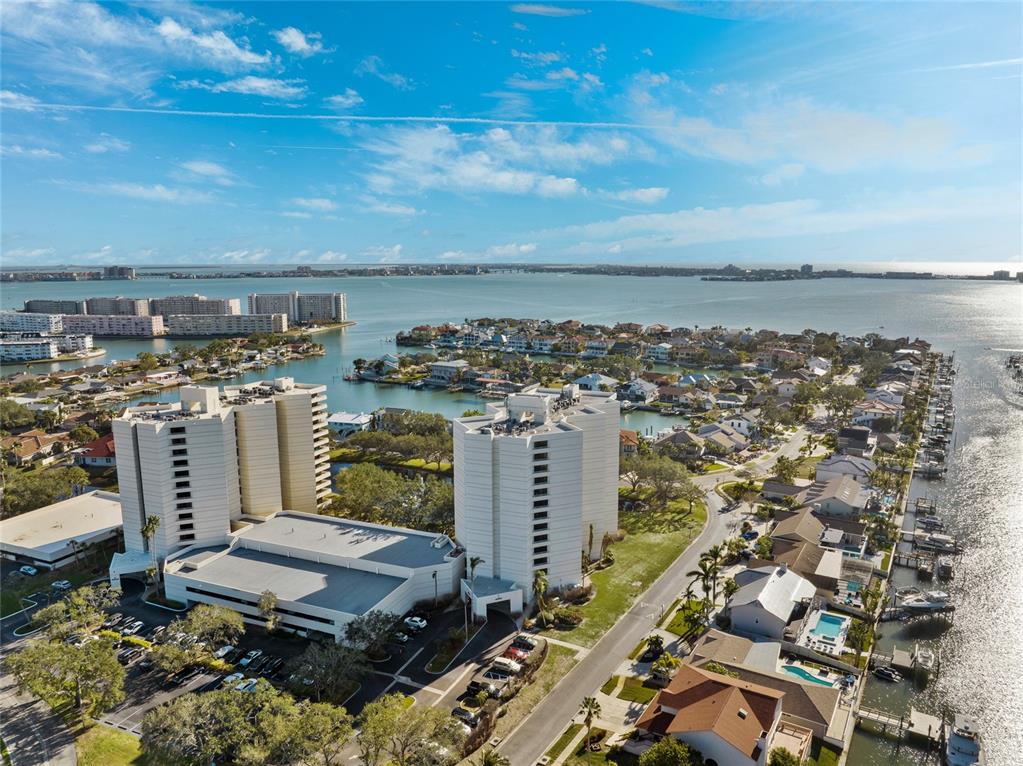 An aerial view shows two high-rise apartment buildings situated near a waterfront residential neighborhood — 5950 PELICAN BAY PLAZA S UNIT 2E, GULFPORT, FL