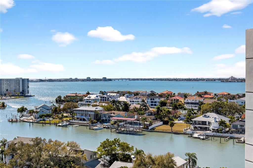 An elevated view of a coastal neighborhood with houses along a canal and a bay — 5950 PELICAN BAY PLAZA S UNIT 2E, GULFPORT, FL