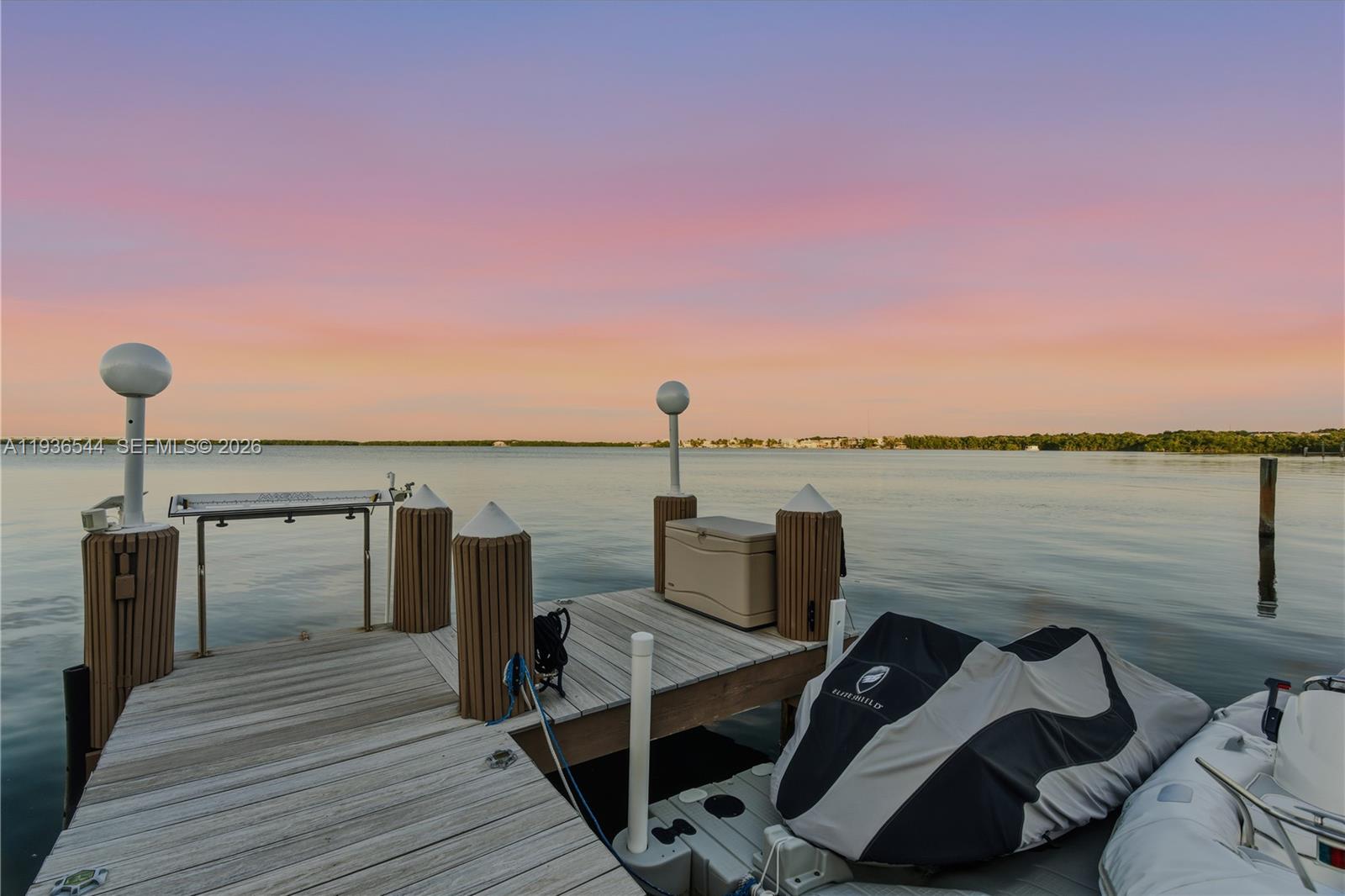 A wooden boat dock features two white globe lights and a covered jet ski — 16 North Dr, Key Largo FL 33037, KEY LARGO, FL
