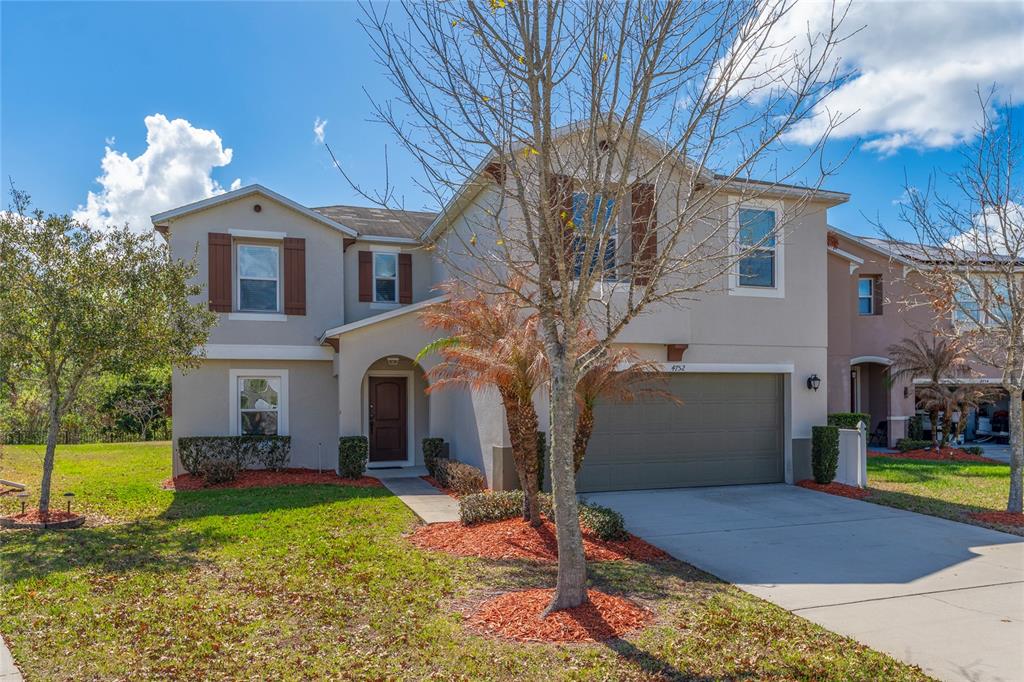 A living room features a dark leather sectional, a wooden coffee table, and tile flooring — 4752 BLUE DIAMOND STREET, KISSIMMEE, FL