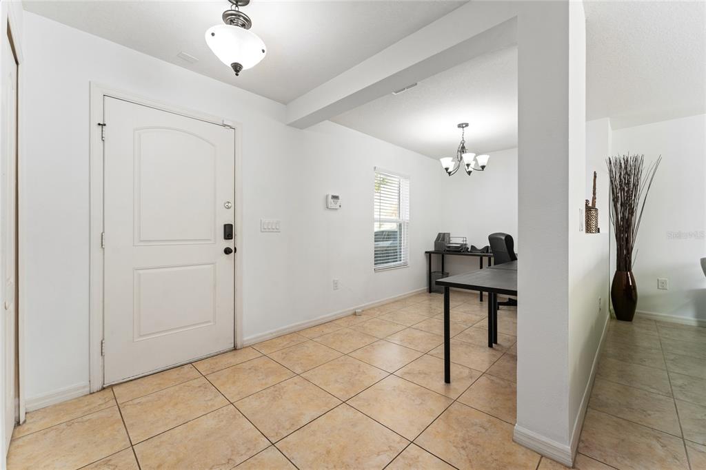 An open-concept dining area and kitchen feature tile flooring, wooden cabinetry, and a carpeted staircase — 4752 BLUE DIAMOND STREET, KISSIMMEE, FL
