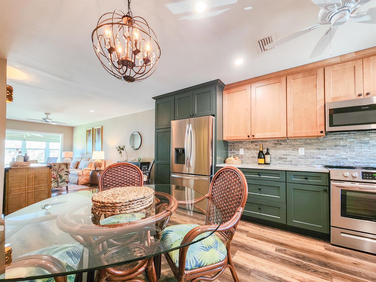 A kitchen with green and wood cabinets, stainless steel appliances, and a glass dining table — 2800 Indian River Boulevard # 8, Vero Beach FL 32960, VERO BEACH, FL