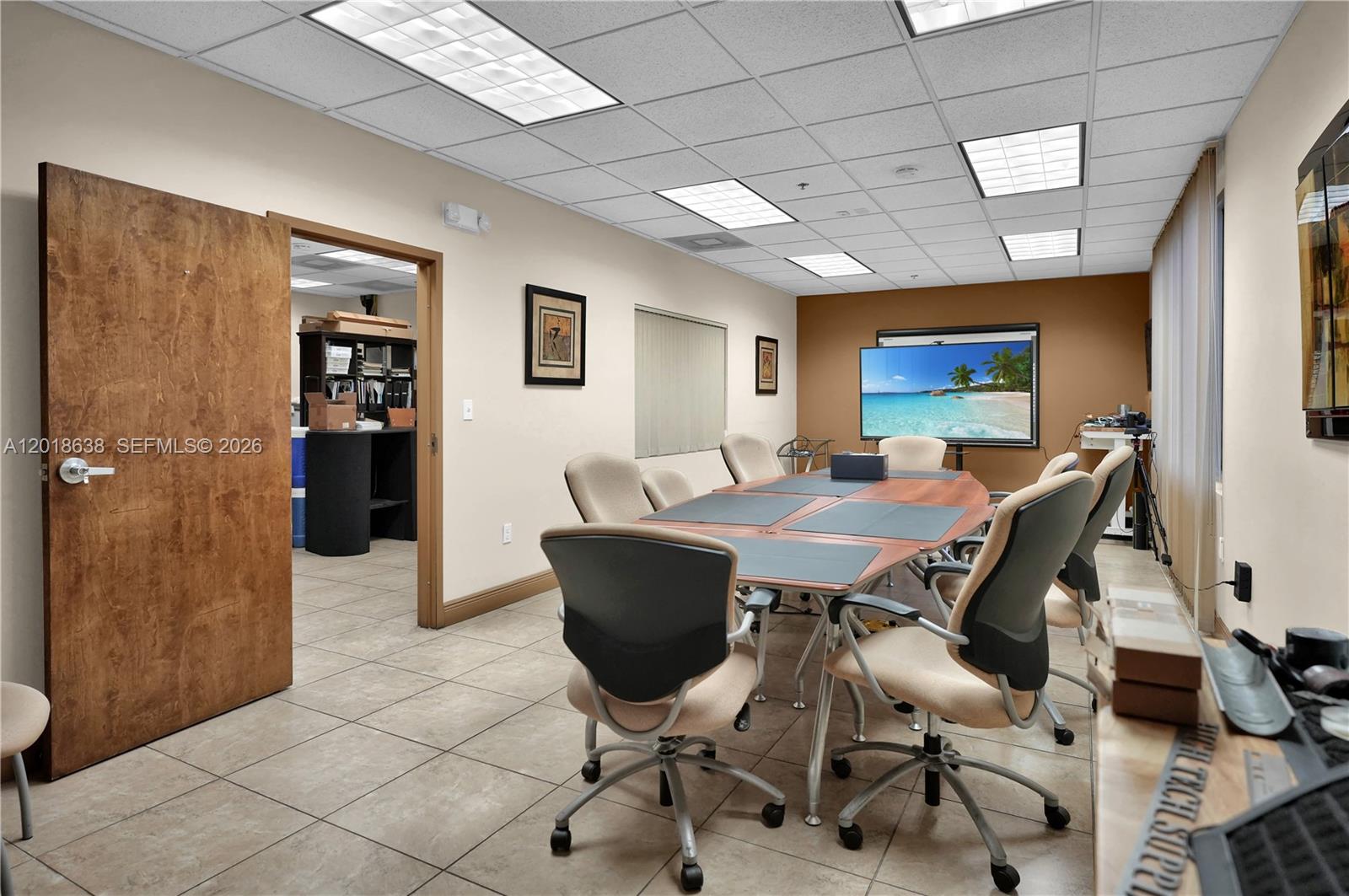 A conference room features a wooden table, office chairs, a television, and tile flooring — 12601 NW 115th Ave # 114, Medley FL 33178, MEDLEY, FL