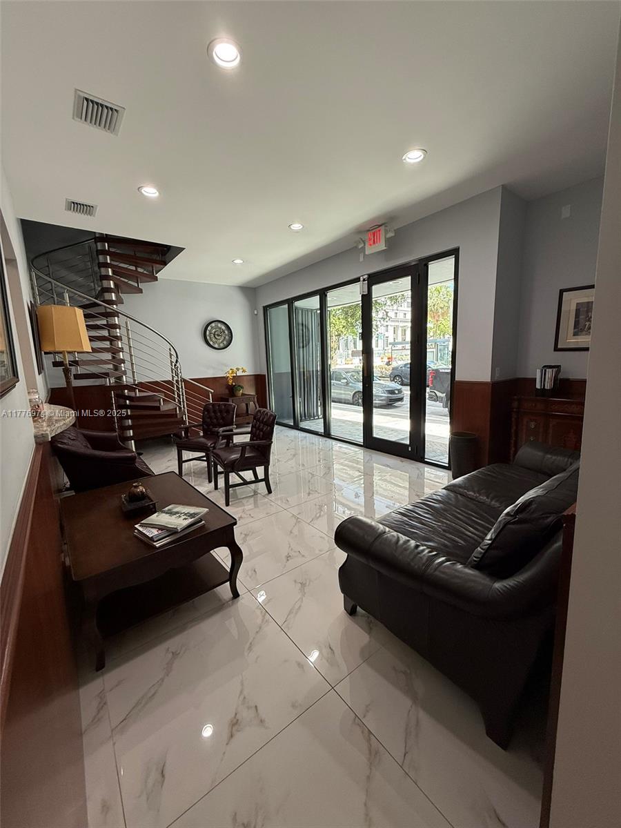 A lobby features a spiral staircase, leather seating, and white marble-look tile flooring — 16 SW 1st Ave, Miami FL 33130, MIAMI, FL