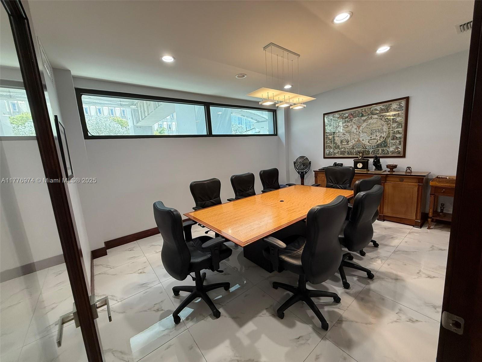 A conference room features a wooden table, black chairs, marble flooring, and a framed map — 16 SW 1st Ave, Miami FL 33130, MIAMI, FL