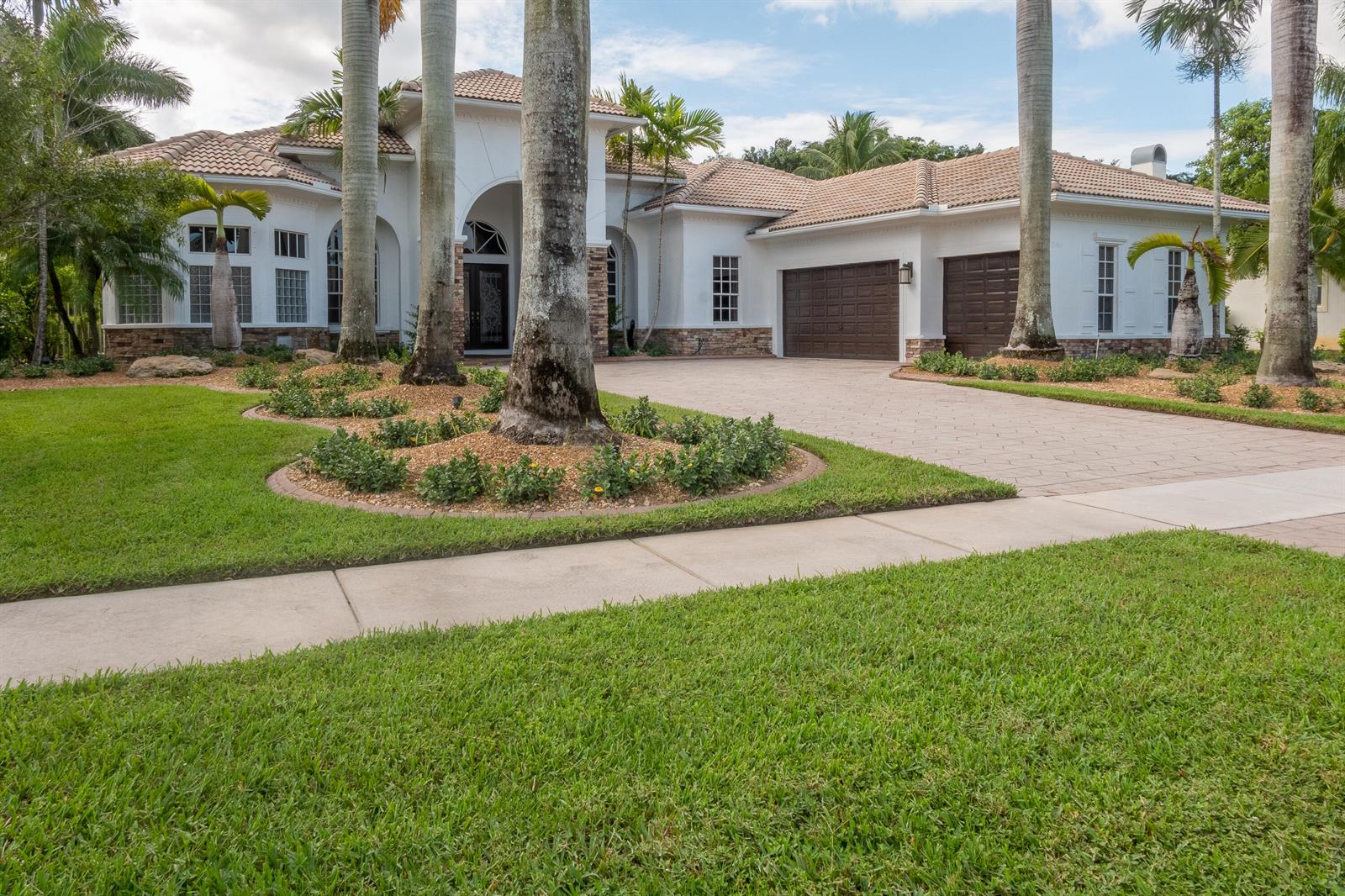 A single-story white house with a tile roof, a paved driveway, and palm trees — 12486 Equine Lane, Wellington FL 33414, WELLINGTON, FL
