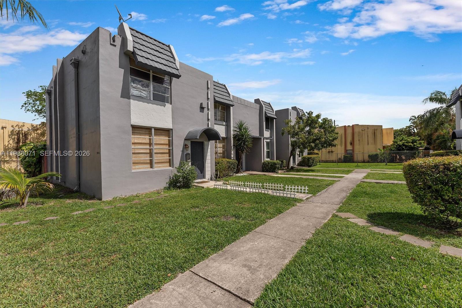 A two-story gray apartment building with a flat roof and a concrete walkway — 314 NE 142 St # 16C, Miami FL 33161, MIAMI, FL