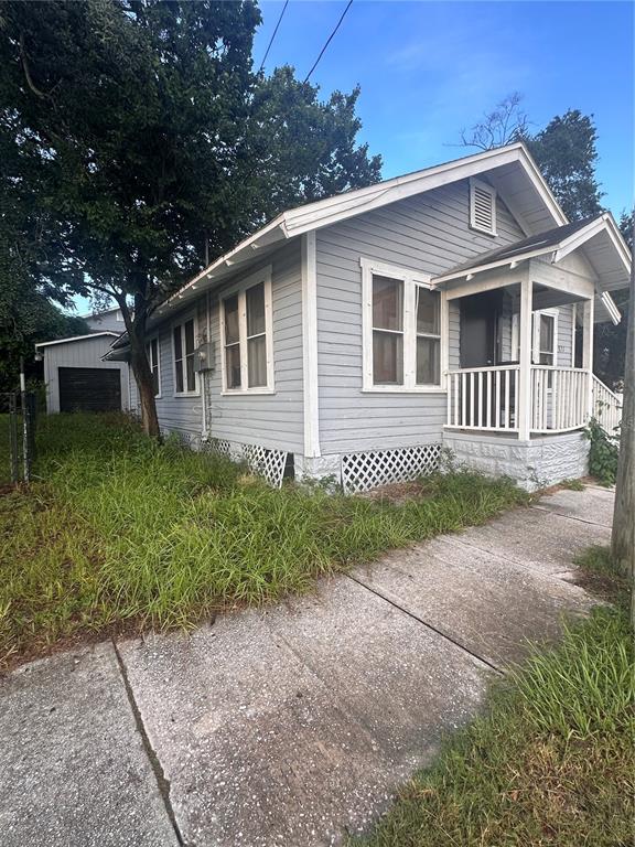 A light gray, single-story house with a front porch and a detached garage — 821 N RIDGEWOOD AVENUE, DAYTONA BEACH, FL