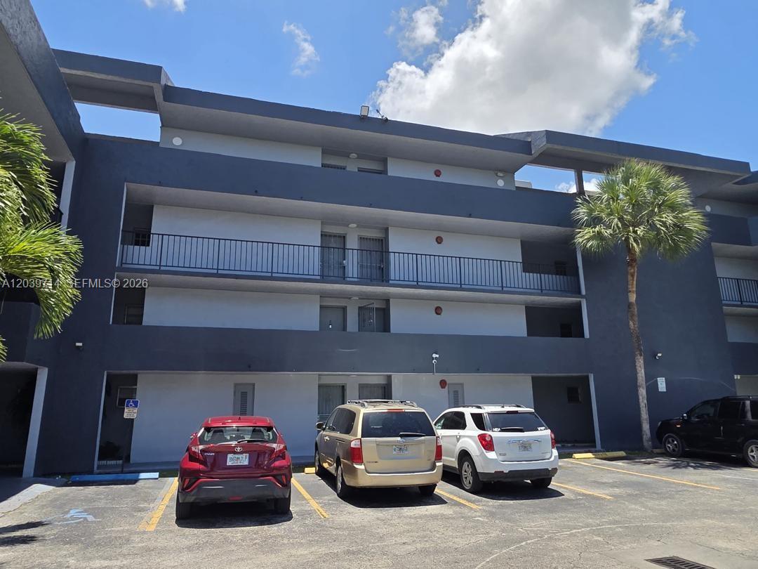 A three-story apartment building exterior with a parking lot in the foreground — 8801 W Flagler St # 104, Miami FL 33174, MIAMI, FL