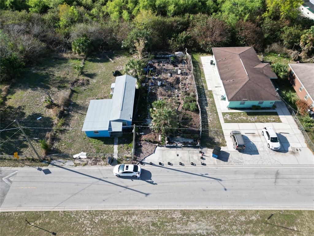 An aerial view shows two adjacent houses with a fenced, overgrown lot between them — 716 AVENUE Y NE, WINTER HAVEN, FL