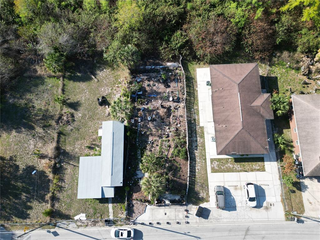 An aerial view shows two houses separated by a narrow, cluttered lot with vegetation — 716 AVENUE Y NE, WINTER HAVEN, FL