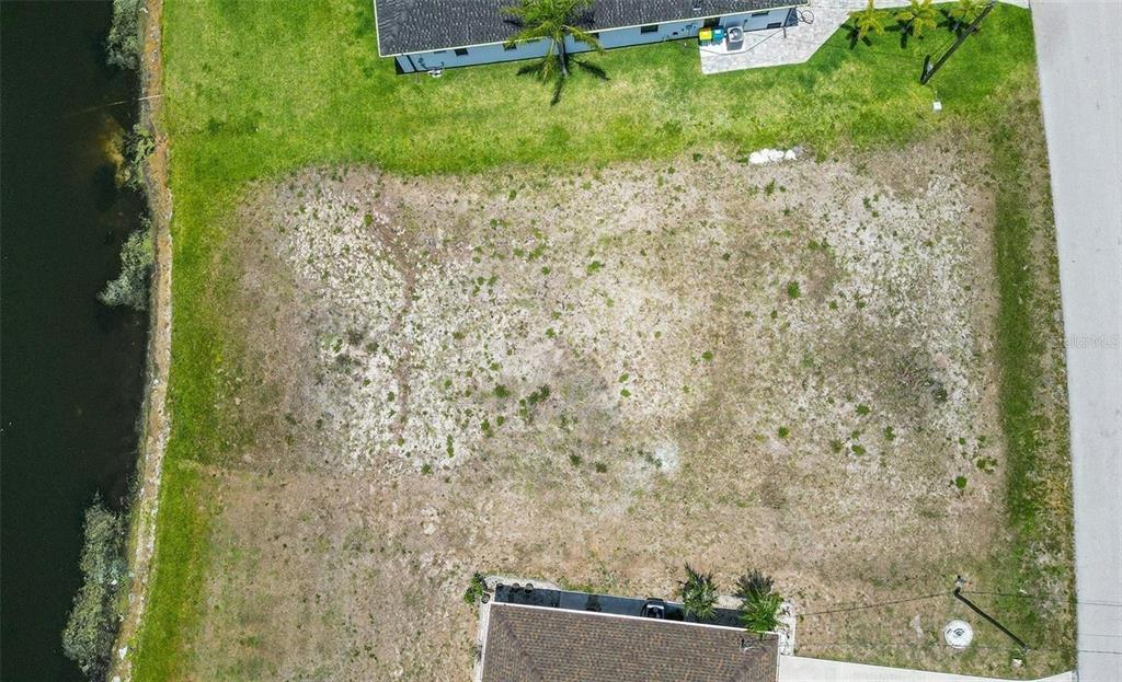 An aerial view shows a vacant, rectangular residential lot situated between two existing houses — 168 MARK TWAIN LANE, ROTONDA WEST, FL