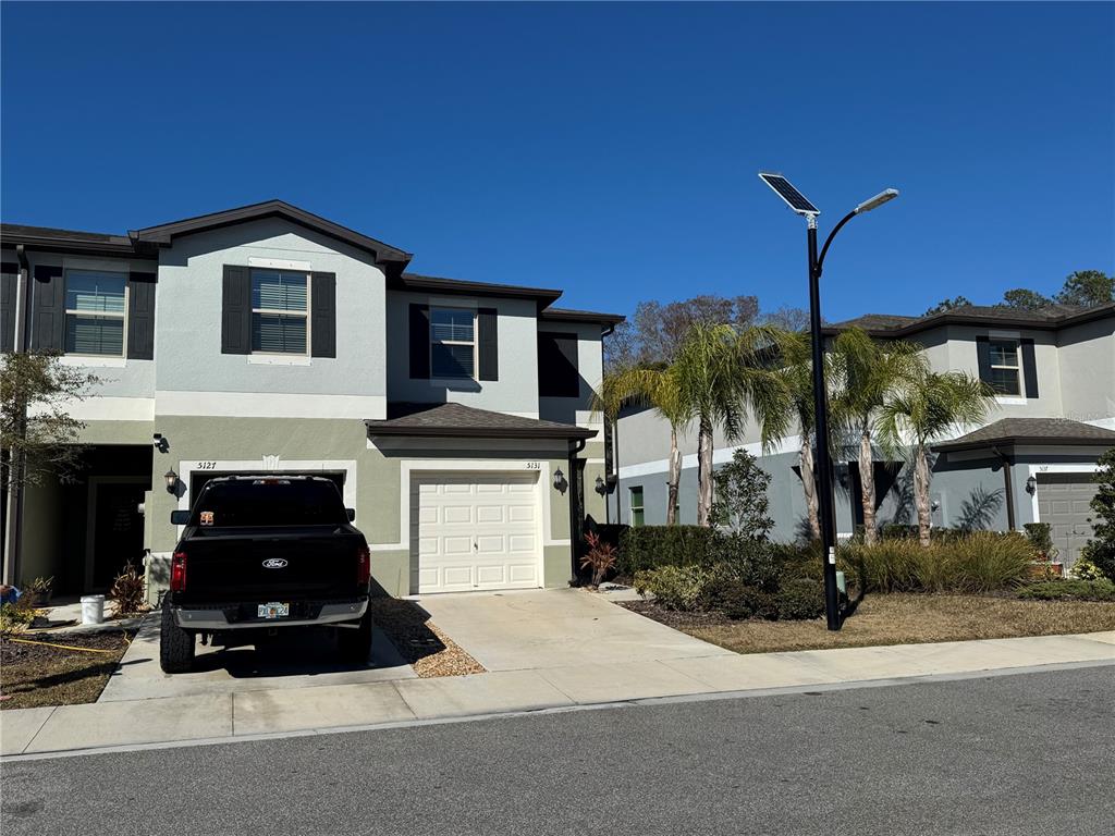 A two-story townhouse with a black pickup truck parked in the driveway — 5131 FORUM BOULEVARD, HOLIDAY, FL