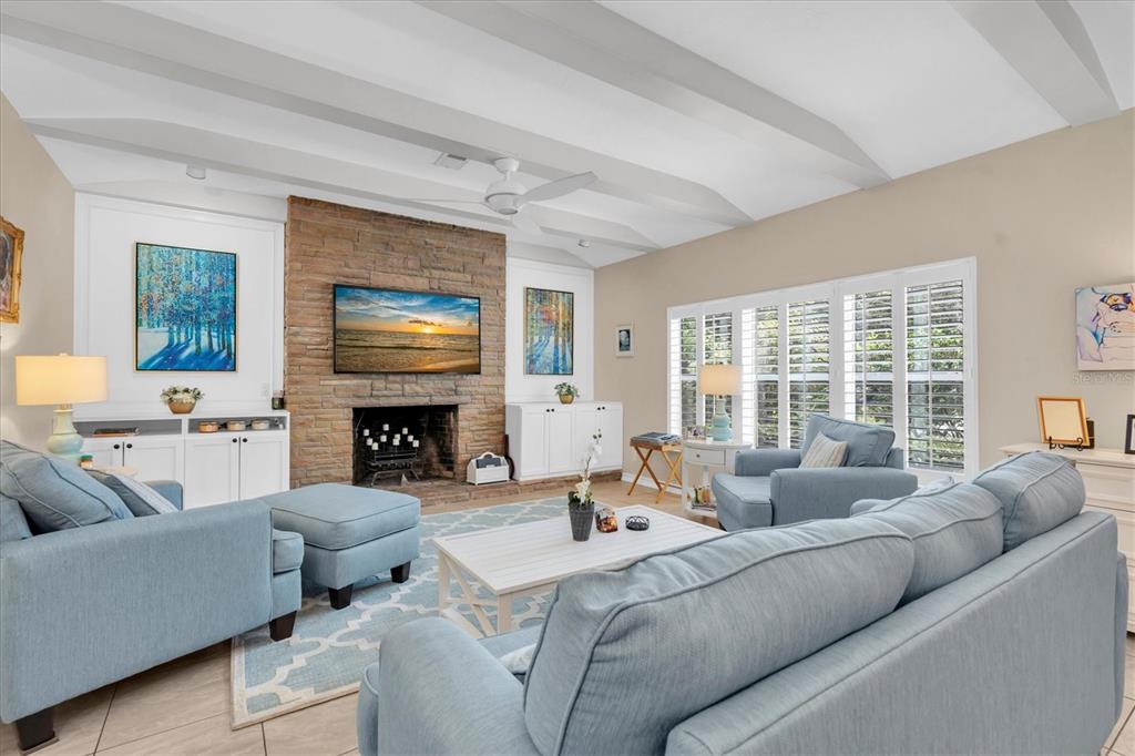 A living room features a stone fireplace, blue furniture, and white vaulted ceilings — 6237 13TH AVENUE S, GULFPORT, FL