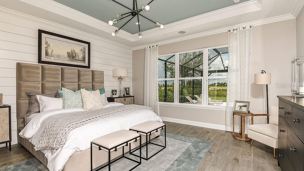 A bedroom features a tufted headboard, shiplap wall, tray ceiling, and a view of a pool — 6933 PRAIRIE OAK WAY, NOKOMIS, FL