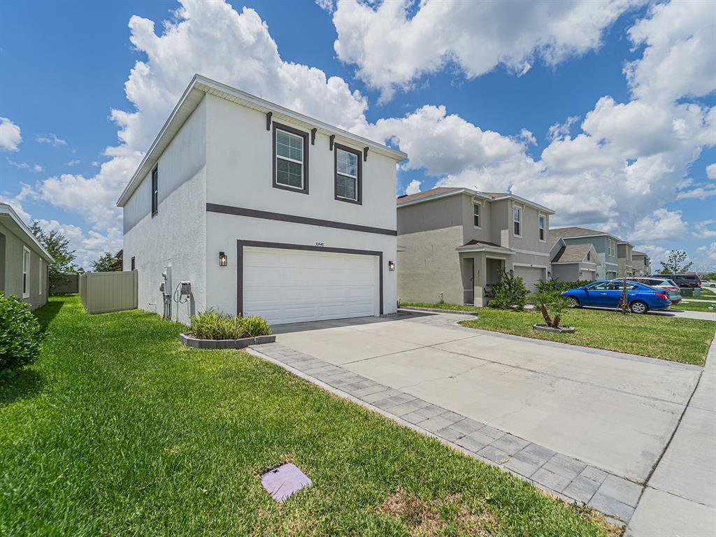 A two-story white house with a two-car garage and a concrete driveway — 31448 PENNY SURF LOOP, WESLEY CHAPEL, FL