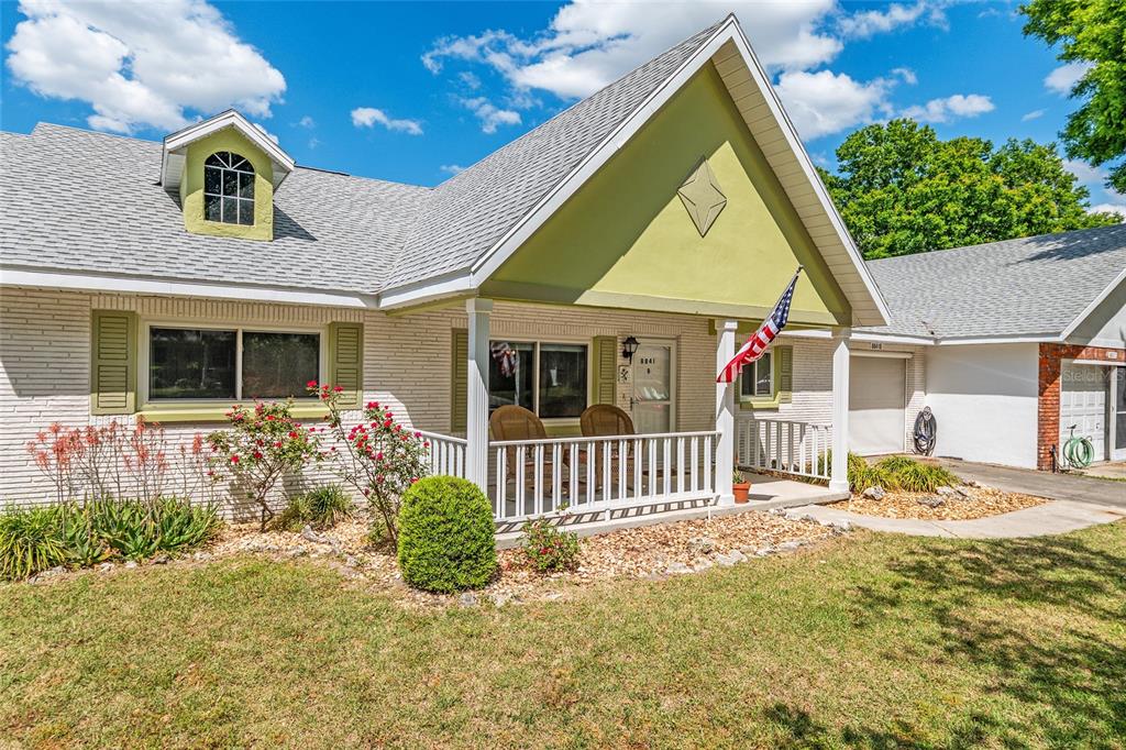 A single-story house with a white brick exterior, a front porch, and a green gable — 8841 SW 91ST STREET UNIT B, OCALA, FL