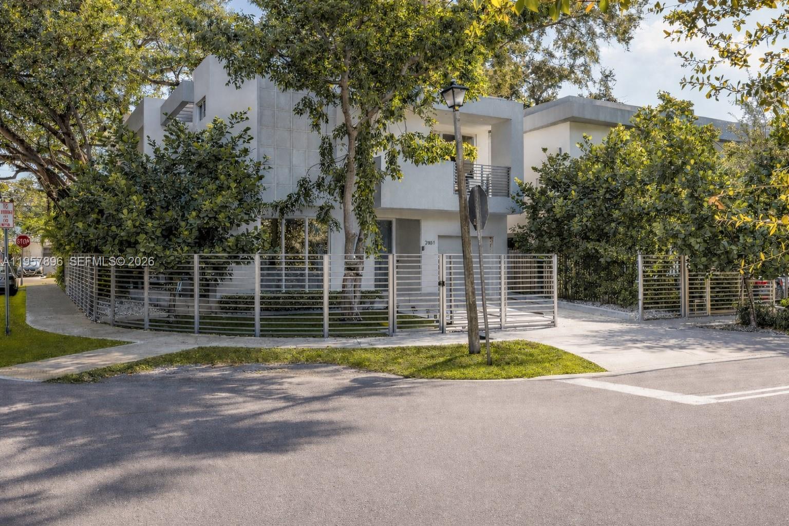 A modern two-story house with a metal fence and lush trees in the front yard — 2851 SW 33rd Ct # 2851, Miami FL 33133, MIAMI, FL