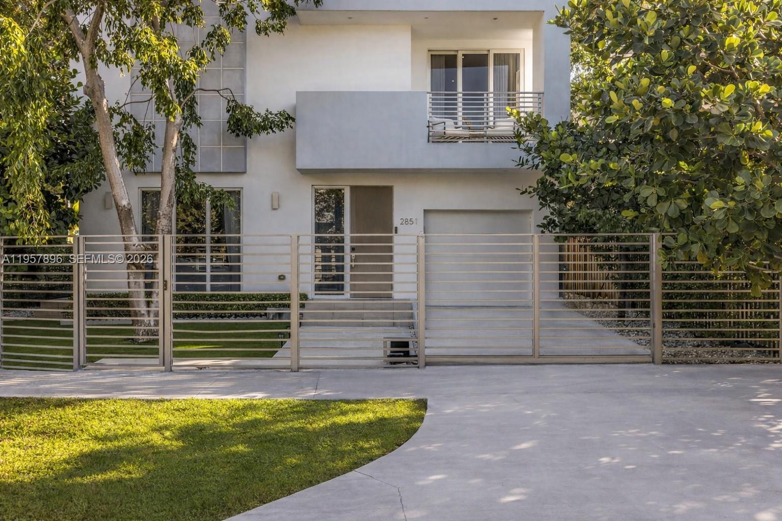 A modern two-story house features a horizontal slat fence, a garage, and a balcony — 2851 SW 33rd Ct # 2851, Miami FL 33133, MIAMI, FL