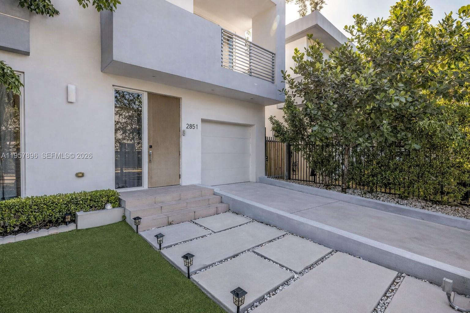 A modern two-story house features a concrete driveway, a front door, and a small lawn — 2851 SW 33rd Ct # 2851, Miami FL 33133, MIAMI, FL