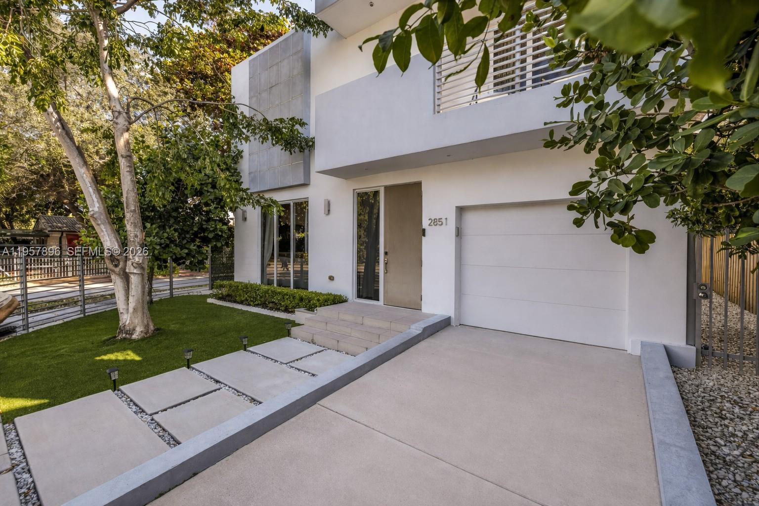 A modern two-story house exterior features a white facade, a garage, and a paved walkway — 2851 SW 33rd Ct # 2851, Miami FL 33133, MIAMI, FL