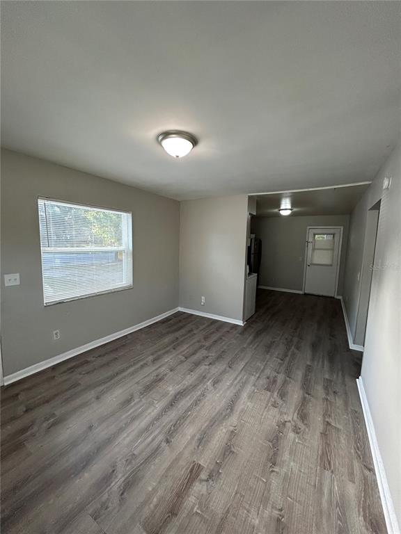 An empty room with gray walls, wood-look flooring, a window with blinds, and ceiling lights — 1484 32ND STREET NW, WINTER HAVEN, FL