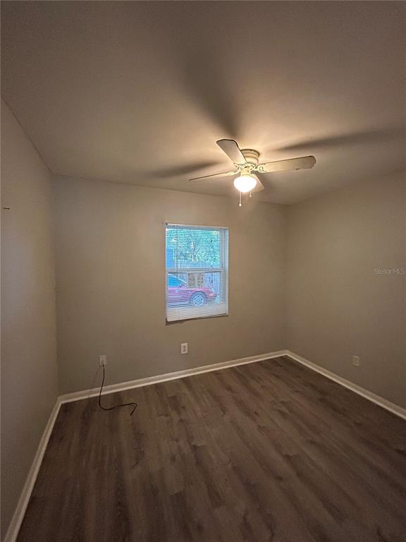 An empty bedroom features light gray walls, wood-look flooring, and a ceiling fan — 1484 32ND STREET NW, WINTER HAVEN, FL