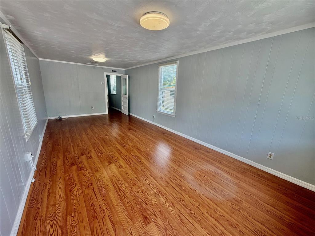 An empty room features light blue paneled walls, wood-look flooring, and two ceiling light fixtures — 270 N BROAD STREET, BROOKSVILLE, FL