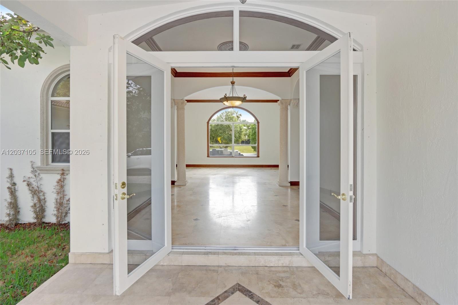 An open double door reveals a bright, tiled foyer with columns and a large window — 8480 SW 98th St, Miami FL 33156, MIAMI, FL