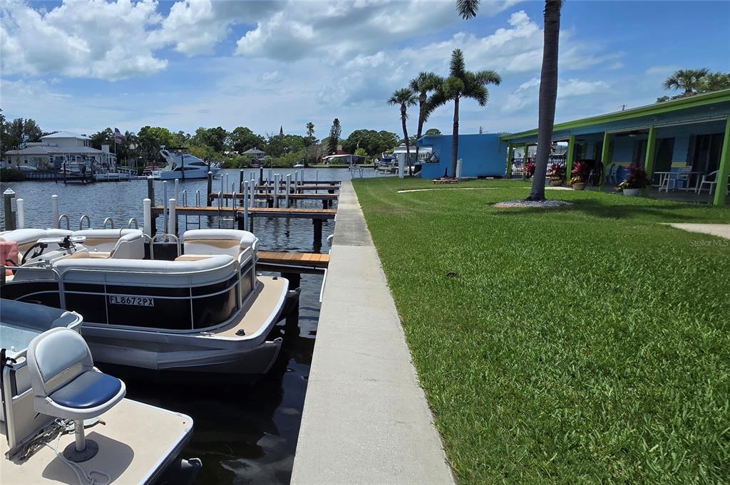A waterfront property features a concrete seawall, a boat dock, and a grassy lawn — 9 YAWL LANE UNIT 9, PALM HARBOR, FL