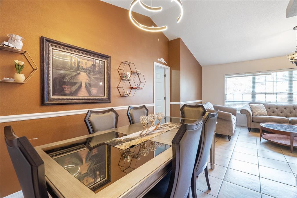 A dining room features a glass-topped table, dark chairs, and brown walls with white trim — 1219 MAYBROOK STREET S, APOPKA, FL