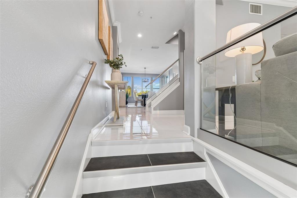 A staircase with dark treads and white risers leads to a bright, open living area — 4326 SPINNAKER COVE LANE, TAMPA, FL