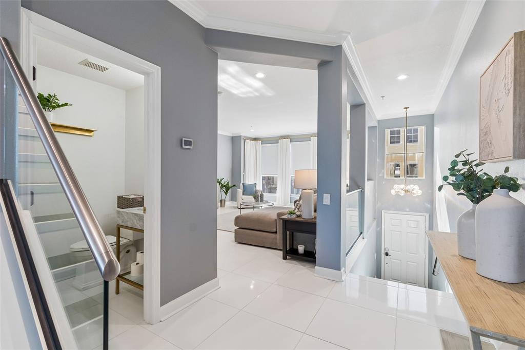 A bright entryway with white tile floors leads to a living area and a bathroom — 4326 SPINNAKER COVE LANE, TAMPA, FL