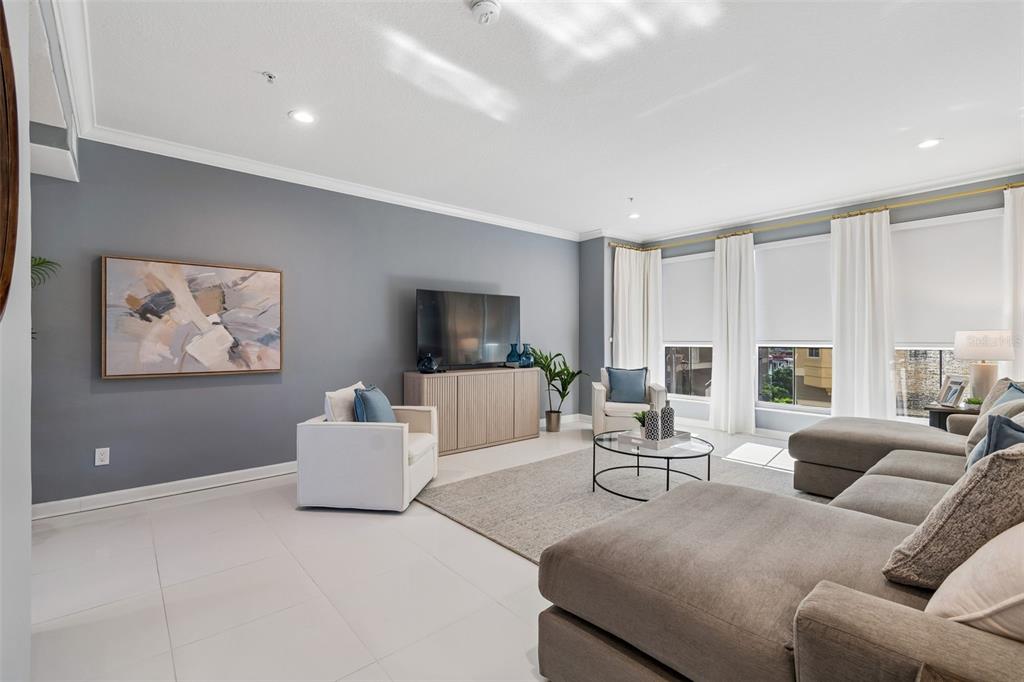 A modern living room features gray walls, white tile floors, a sectional sofa, and windows — 4326 SPINNAKER COVE LANE, TAMPA, FL