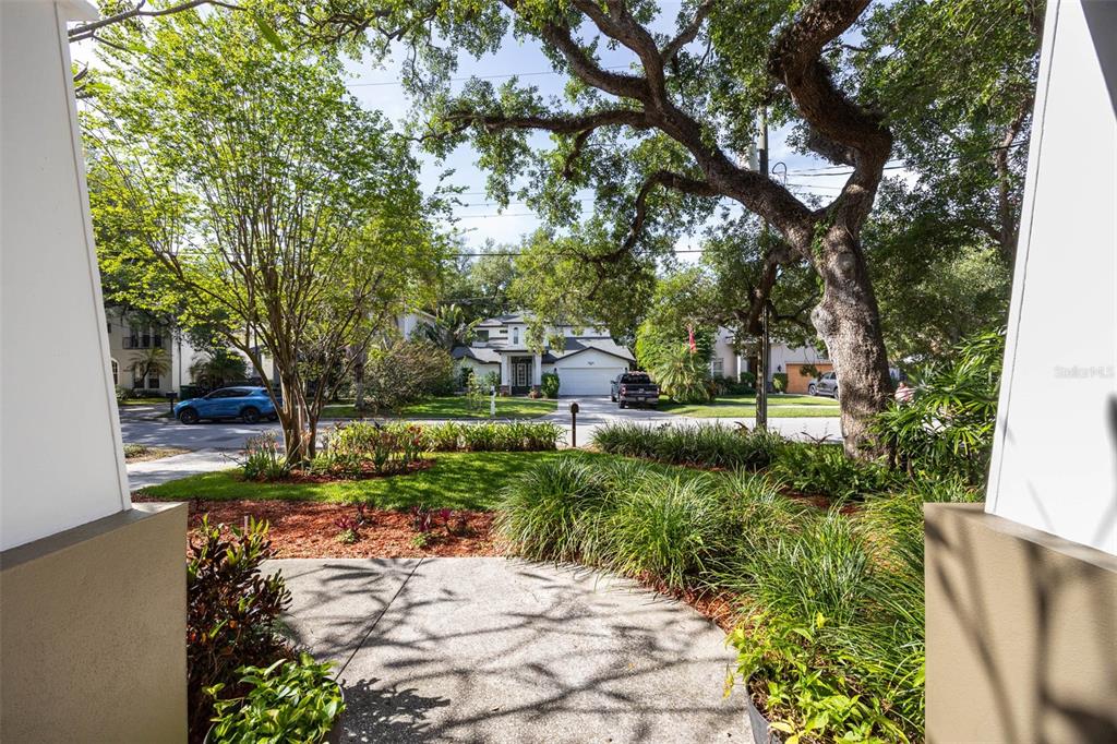A view from a porch looking out at a suburban street with trees and houses — 3311 W HAWTHORNE ROAD, TAMPA, FL