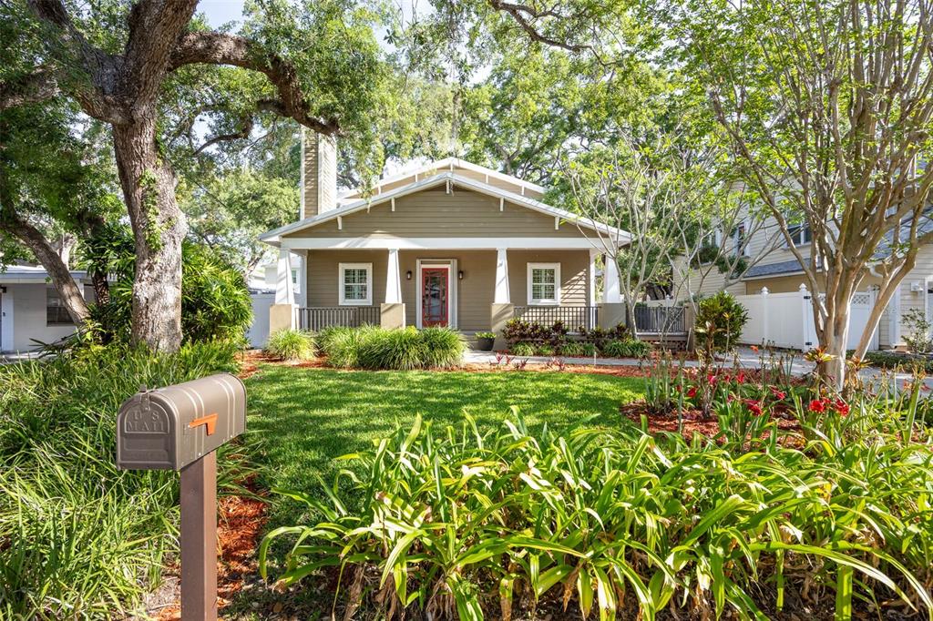 A tan bungalow with a front porch, white columns, and a mailbox in the yard — 3311 W HAWTHORNE ROAD, TAMPA, FL