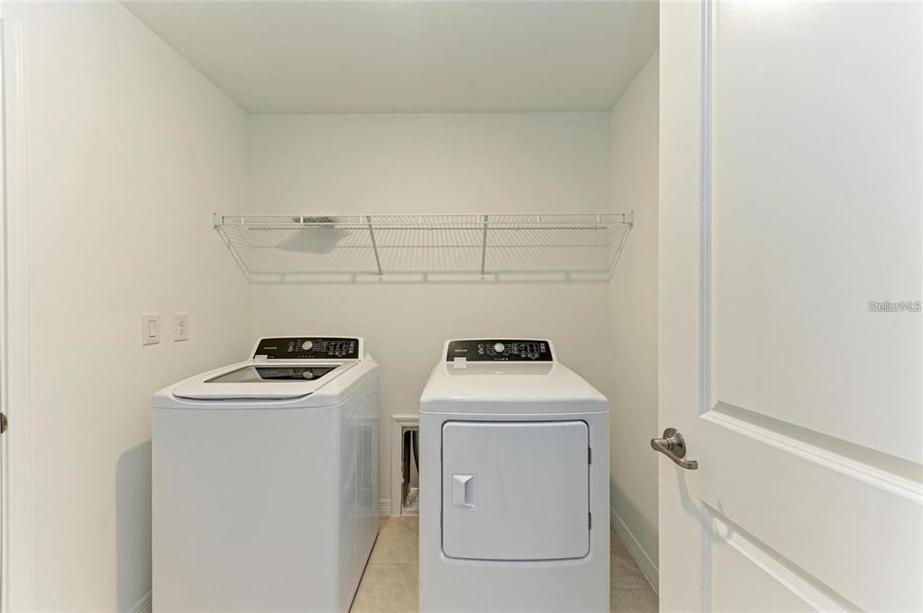 A laundry closet contains a white top-load washer and a front-load dryer — 1485 PULASKI STREET, PORT CHARLOTTE, FL