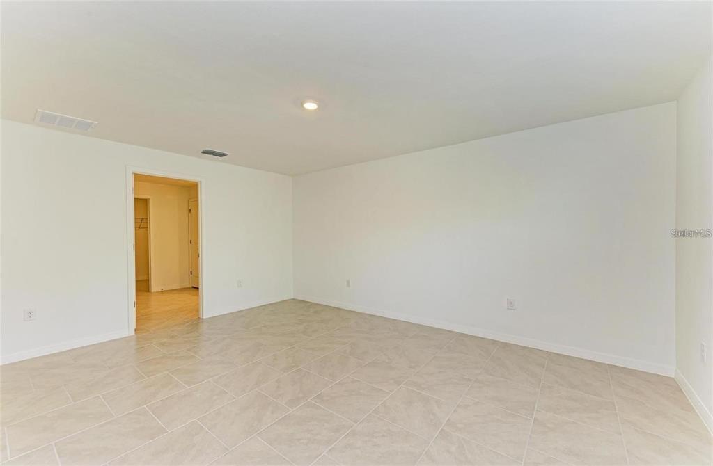 An empty room features light-colored tile flooring, white walls, and a recessed ceiling light — 1485 PULASKI STREET, PORT CHARLOTTE, FL