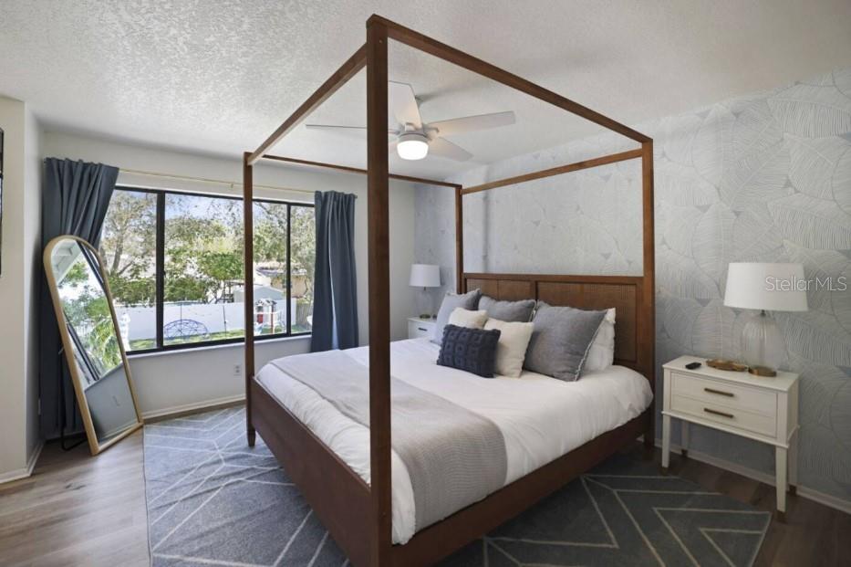 A bedroom features a wooden canopy bed, a patterned area rug, and a large window — 10075 W BAY STREET, SEMINOLE, FL
