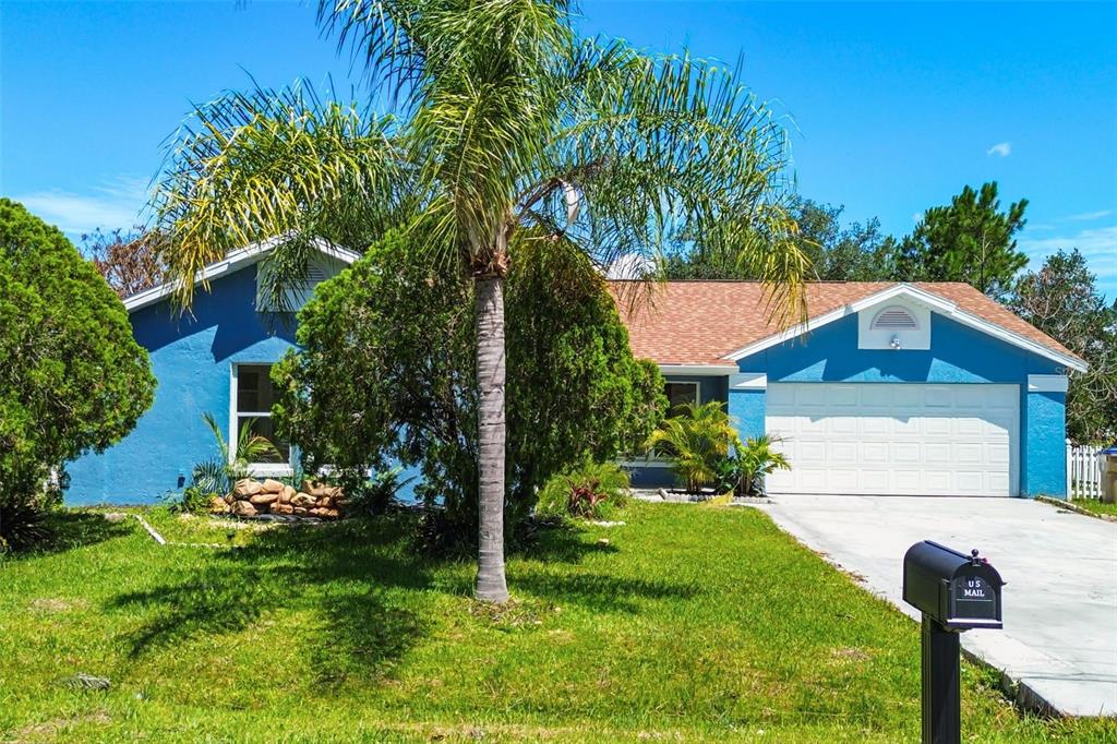 A blue single-story house with a palm tree in the front yard and a garage — 760 DEL PRADO DRIVE, KISSIMMEE, FL