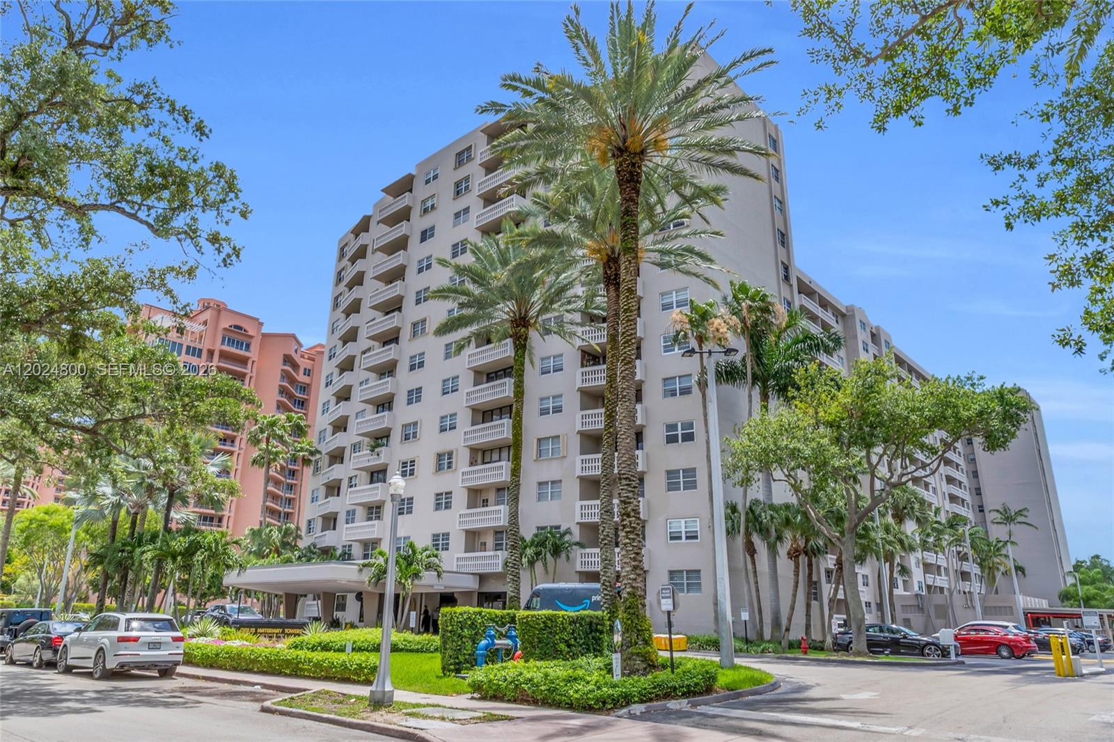 A multi-story residential apartment building stands surrounded by palm trees and landscaped grounds — 90 Edgewater Dr # 1201, Coral Gables FL 33133, CORAL GABLES, FL
