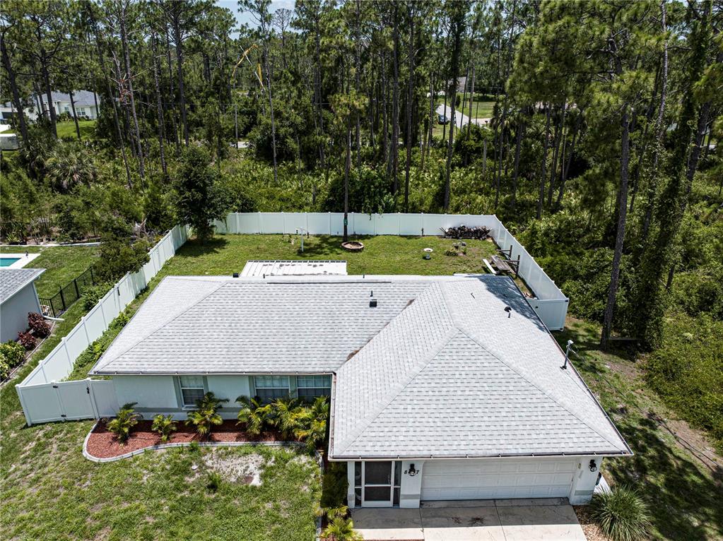 An aerial view shows a single-story house with a gray roof, white fence, and backyard — 8457 BRISTOL AVENUE, NORTH PORT, FL