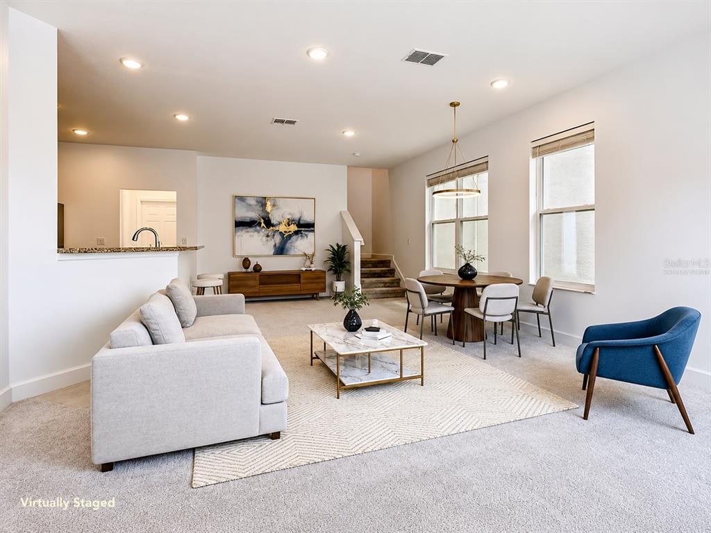 A living and dining area with a sofa, coffee table, and round dining table — 148 BOYDFIELD LANE, DAVENPORT, FL