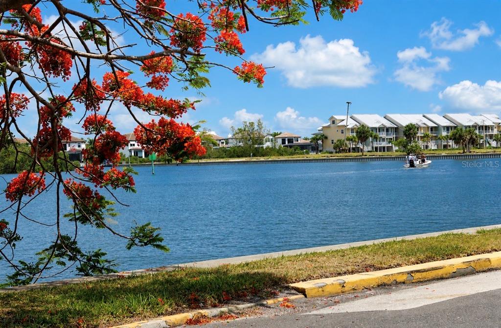 A view of a calm blue waterway with a boat and waterfront residential buildings — 611 DESTINY DRIVE UNIT 307, RUSKIN, FL