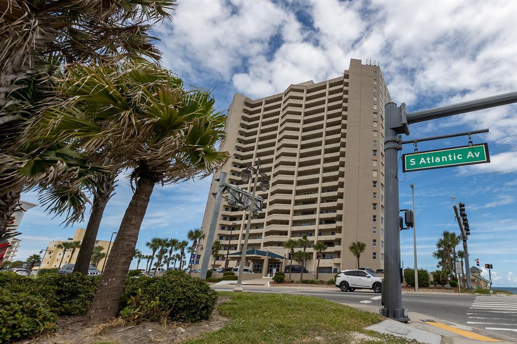 A tall, tan high-rise condominium building stands behind a street sign on S Atlantic Av — 3425 S ATLANTIC AVENUE UNIT 1102, DAYTONA BEACH, FL